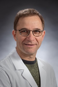 Dr. Amit Bar-Or in white lab coat